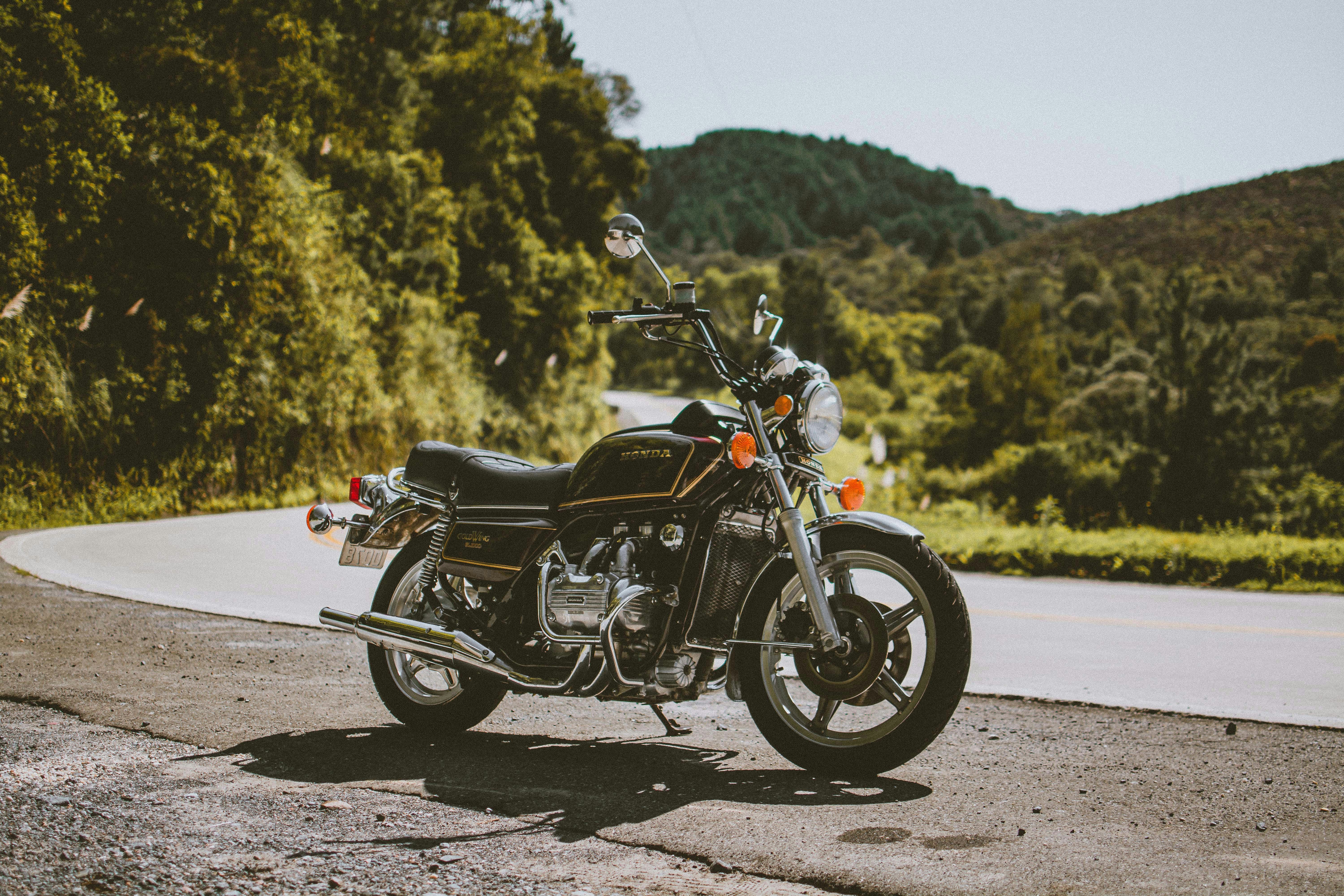 black and silver cruiser motorcycle on gray asphalt road during daytime